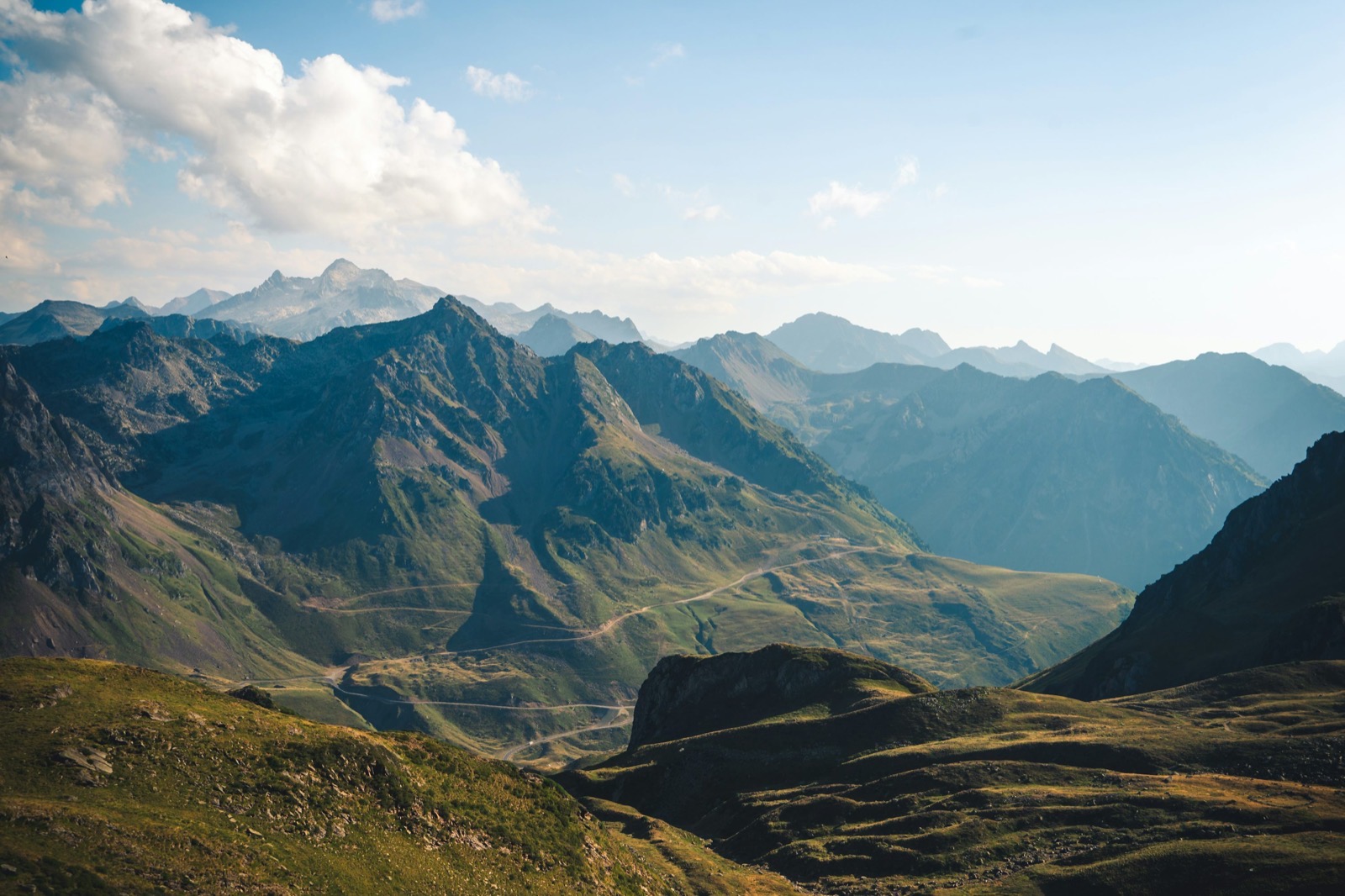A mountain range rising in layered ridges above green valleys
