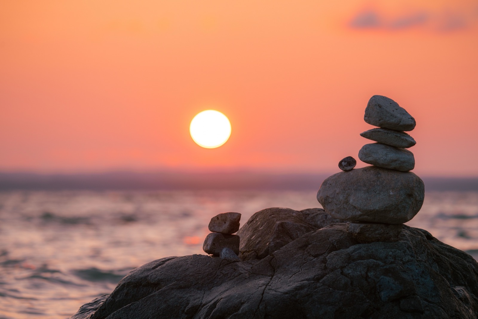 Balanced stones standing calm at warm sunset